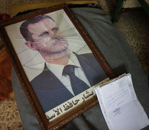 Un portrait du président syrien Bashar al-Assad est photographié avec son cadre brisé, dans un bâtiment de la Direction de la sécurité politique du régime syrien à la périphérie de la ville centrale de Hama, après la prise de la zone par les forces anti-gouvernementales, le 7 décembre 2024. Omar Haj Kadour / AFP