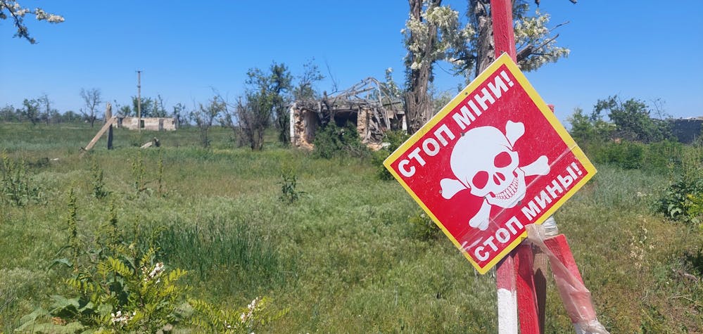 Des panneaux de mines indiquent les endroits où des mines ont été posées à l'intérieur et autour d'objets civils détruits à Bezimmine, dans l'oblast de Kherson.