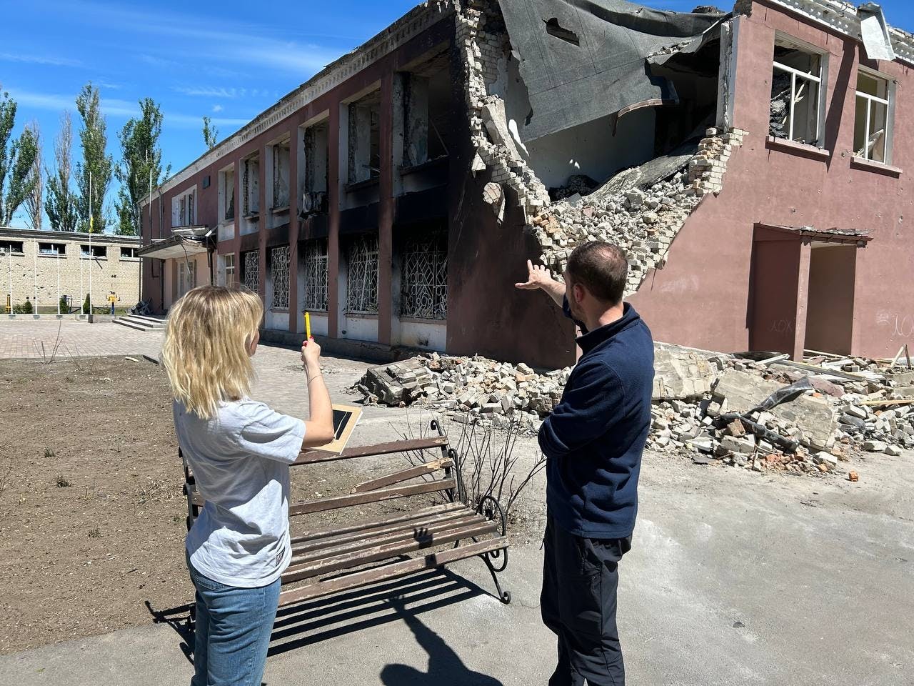 Patrick Thompson et Anna Wright devant une école détruite dans l'oblast de Mykolaiv.