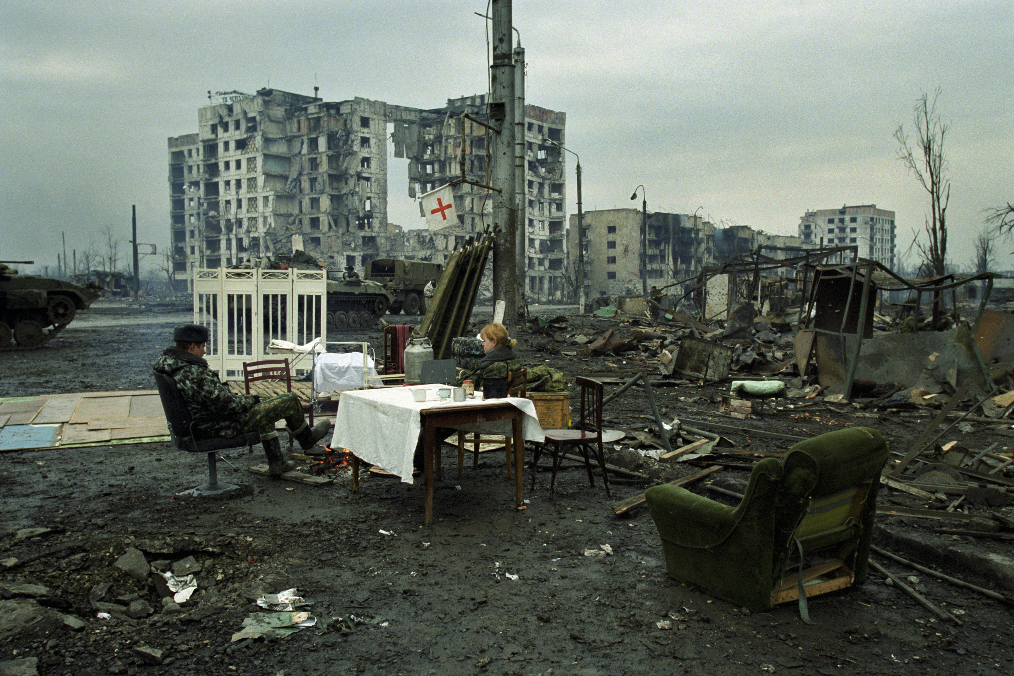 Grozny, 4 février 2000. Sur la place Minoutka, des soldats se détendent sur des chaises qu’ils ont récupérées dans les ruines. © Dmitri Beliakov