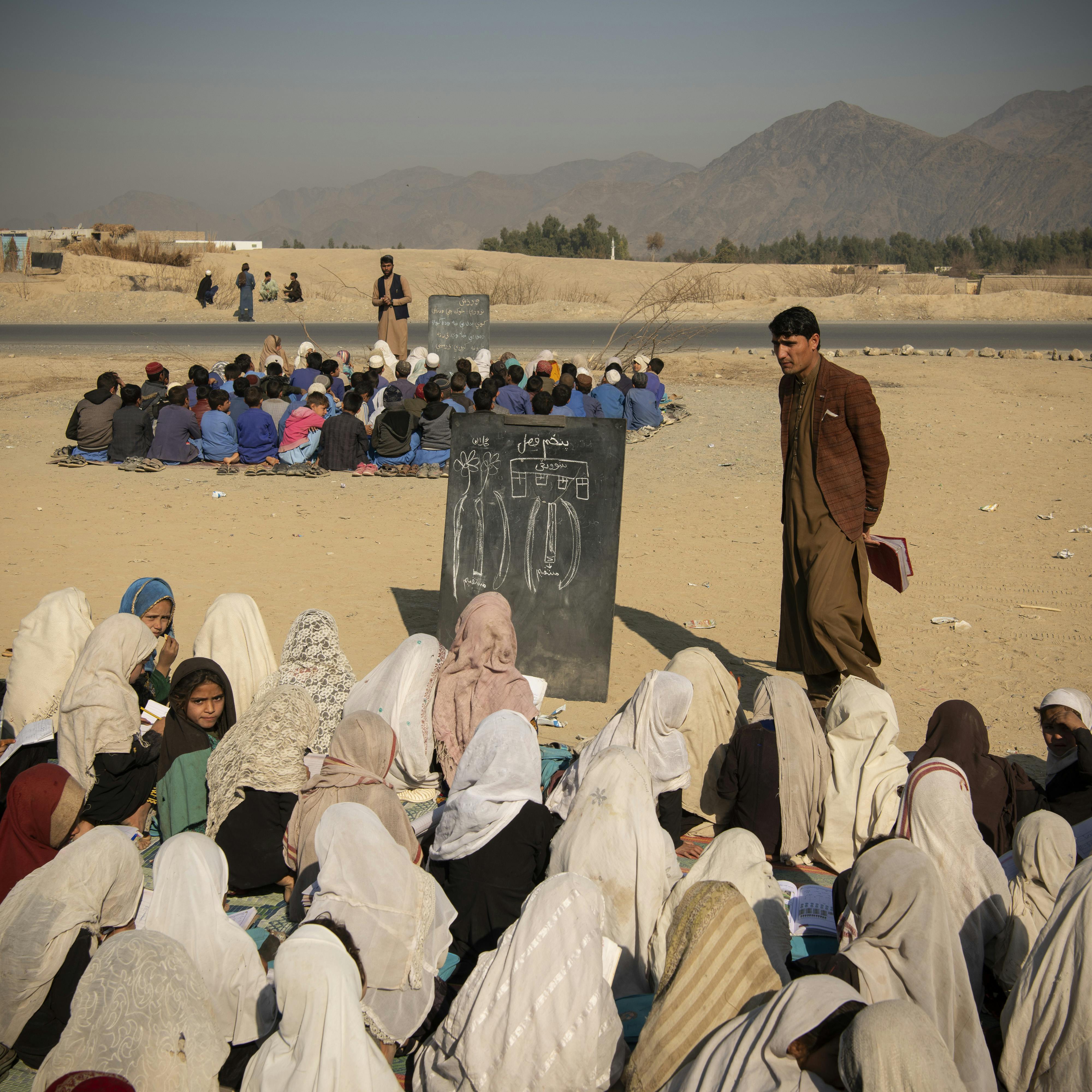 Gardi, district de Ghosta, Nangarhar, Afghanistan, 13 février 2024. En l’absence de bâtiments scolaires dans le district de Gardi Ghos, des classes sont installées pour les élèves, entre deux routes principales, sous le soleil et sur un sol en terre battue. © Kiana Hayeri pour la Fondation Carmignac