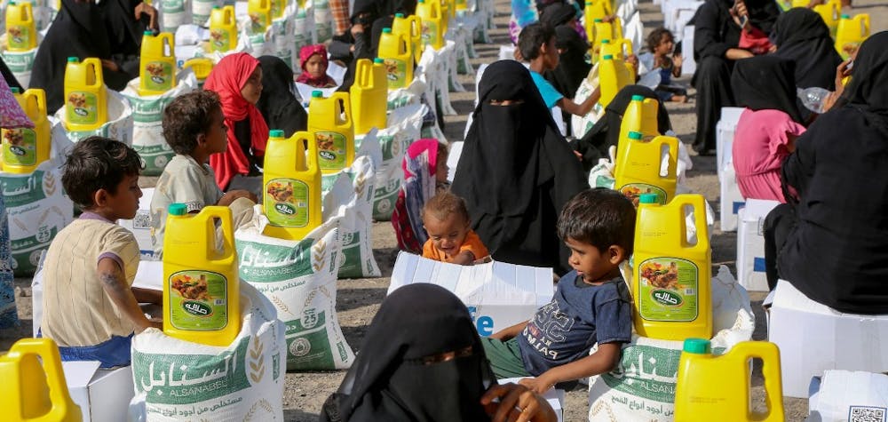 Des Yéménites déplacés reçoivent une aide humanitaire fournie par des Yéménites expatriés aux États-Unis, dans la région d'al-Khokha au Yémen, le 12 mars 2024.