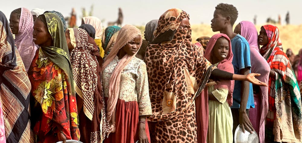 Le 13 avril 2025, des personnes ayant fui le camp de déplacés de Zamzam, tombé sous le contrôle des Forces de soutien rapide, font la queue pour obtenir des rations alimentaires dans un campement de fortune situé dans un champ près de la ville de Tawila, dans la région du Darfour occidental, déchirée par la guerre, au Soudan.