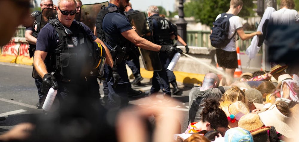 Des manifestant·es se font gazer par la police à Paris le 28 Juin 2019 lors d’une action climatique sur un pont.