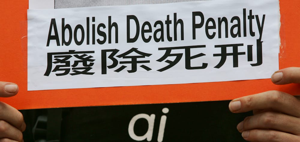 A protester from human rights group Amnesty International, carrying a placard demanding the abolition of death penalty in mainland China, demonstrate outside a Chinese liaison office in Hong Kong July 14, 2005. Amnesty International estimates that China executed at least 3,400 people in 2004. 