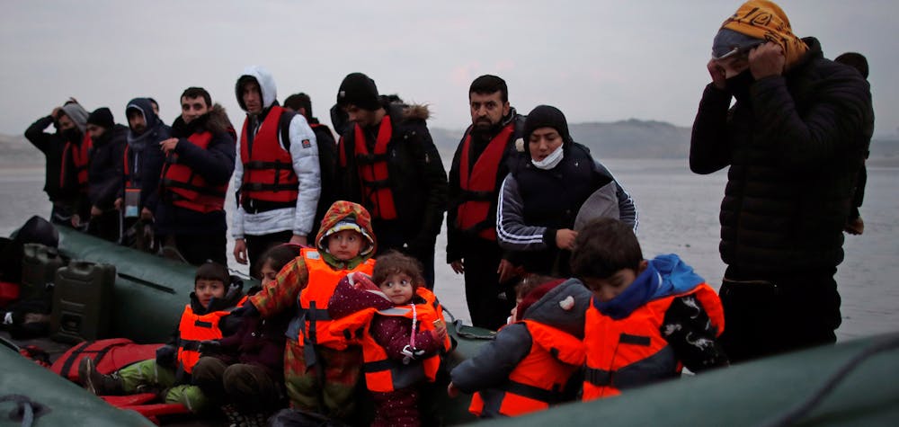 Un groupe de plus de 40 migrants avec des enfants monte à bord d'un canot pneumatique alors qu'ils quittent les côtes du nord de la France pour traverser la Manche, près de Wimereux, France. Photo prise le 24 novembre 2021