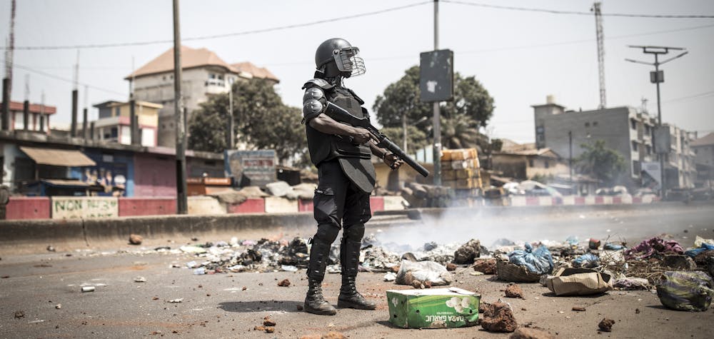 A policeman stands along the "axis of democracy" as protests broke out in Conakry on February 29, 2020. - Guinea's President Alpha Conde announced on February 28, 2020 a "slight postponement" of March 1's referendum on whether to adopt a new constitution, following mounting international criticism over the poll's fairness. (Photo by JOHN WESSELS / AFP)