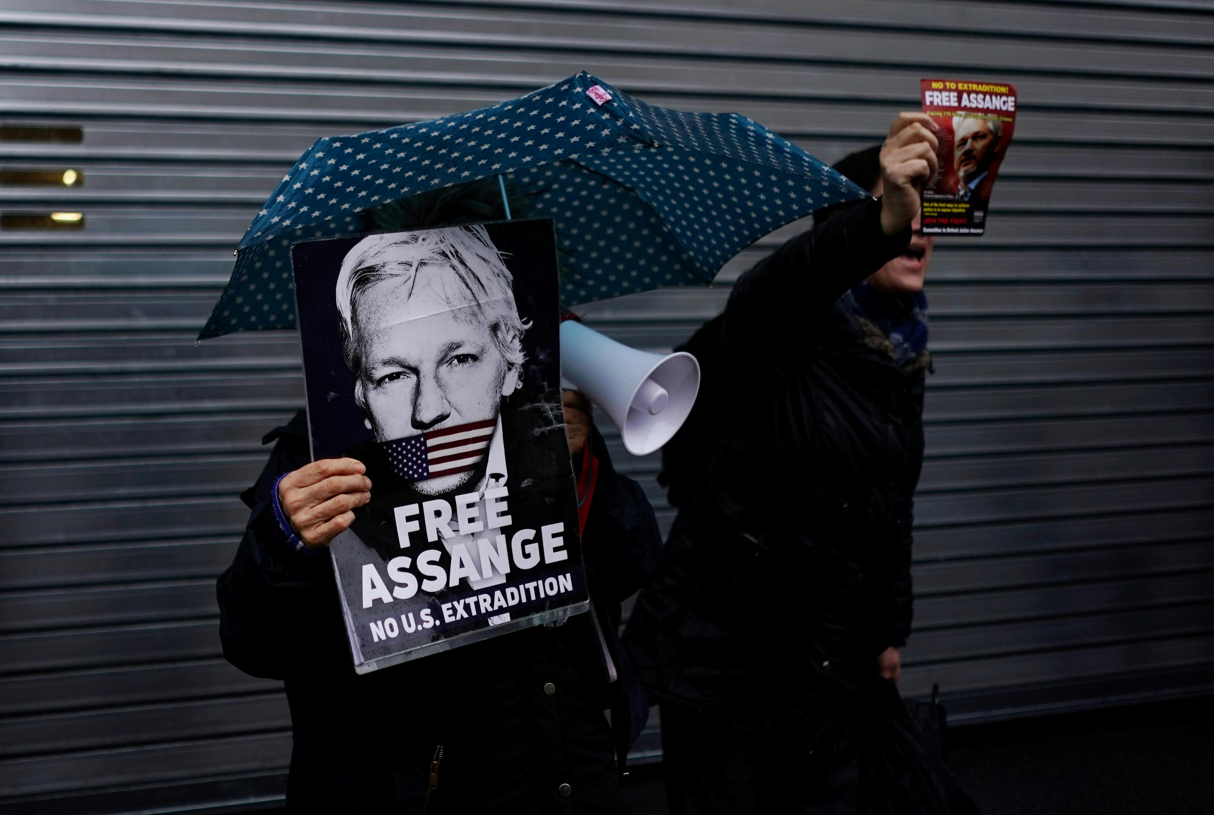 Demonstrators hold placards ahead of WikiLeaks founder Julian Assange appearing before the Spanish High Court via videolink, in London, Britain, December 20, 2019. REUTERS/Henry Nicholls