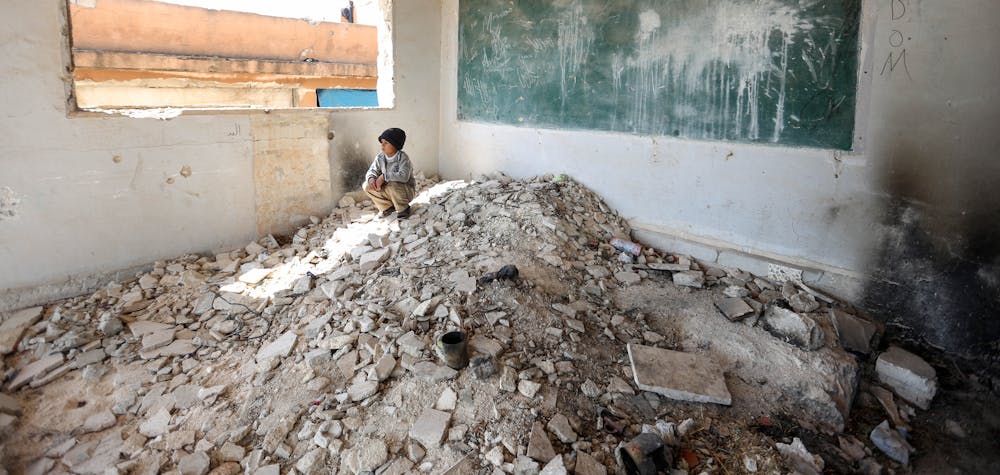  	IDLIB, SYRIA - APRIL 02: A Syrian kid is seen amid the ruin of a school after displaced by bombardments of Assad Regime and its supporter Russia in Idlib, Syria on April 02, 2020. Sixteen Syrian families take shelter in two school ruins in the north eastern district of the city.