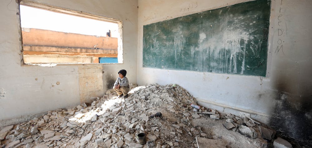  	IDLIB, SYRIA - AaPRIL 02: A Syrian kid is seen amid the ruin of a school after displaced by bombardments of Assad Regime and its supporter Russia in Idlib, Syria on April 02, 2020. Sixteen Syrian families take shelter in two school ruins in the north eastern district of the city.