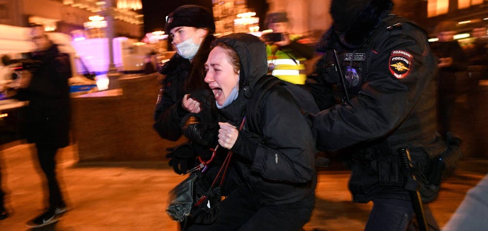 Deux policiers russes arrêtent une personne lors d'une manifestation contre l'invasion de l'Ukraine par la Russie, à Moscou le 24 février 2022 / © Alexandre NEMENOV via AFP