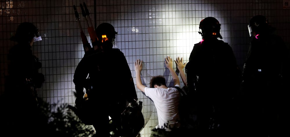 Men detained by riot police kneel by a wall after a protest at Yuen Long station against violence that happened two months ago when white-shirted men wielding pipes and clubs wounded both anti-government protesters and passers-by, in Hong Kong, China September 21, 2019. Picture taken September 21, 2019. REUTERS/Tyrone Siu