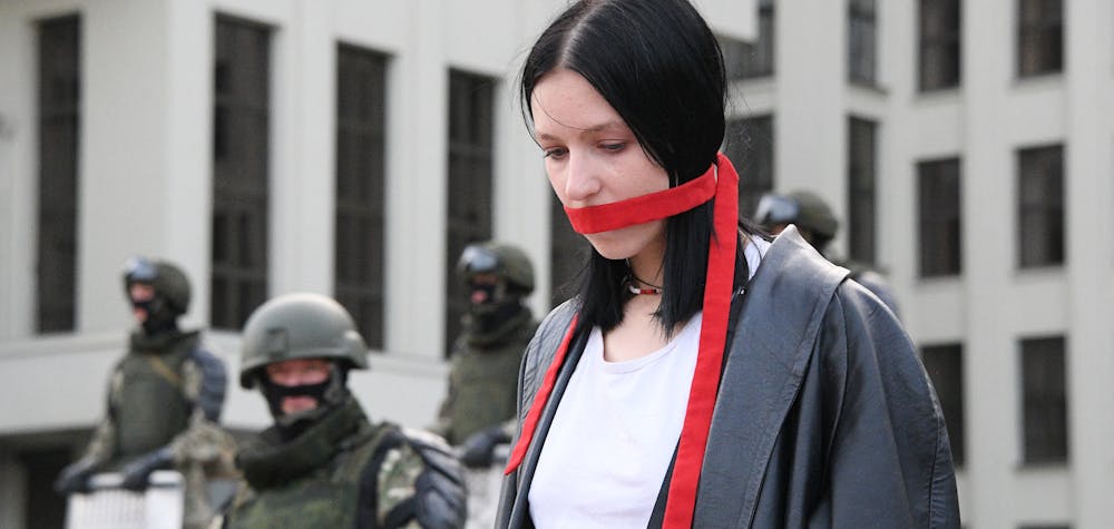 6308398 14.08.2020 A woman stands in front of members of Belarusian Interior Ministry troops as she attends an opposition demonstration to protest against police violence and to reject the presidential election results near the Government House in Independence Square in Minsk, Belarus. Viktor Tolochko / Sputnik