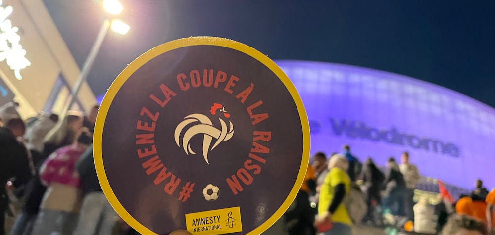 Action de tractage pour sensibiliser les supporters de l'équipe de France à la situation des travailleurs migrants au Qatar, Orange Vélodrome, à Marseille, mars 2022