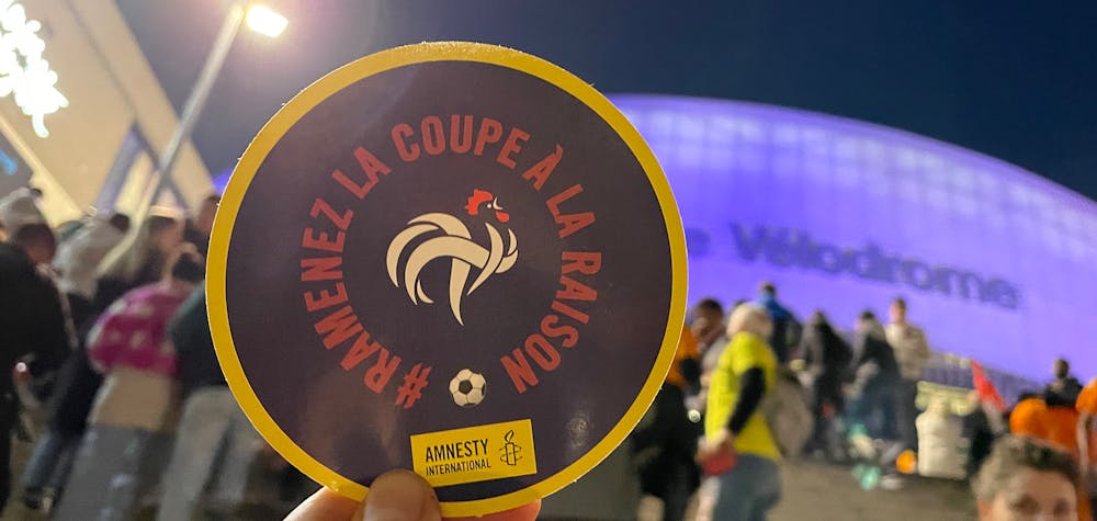 Action de tractage pour sensibiliser les supporters de l'équipe de France à la situation des travailleurs migrants au Qatar, Orange Vélodrome, à Marseille, mars 2022