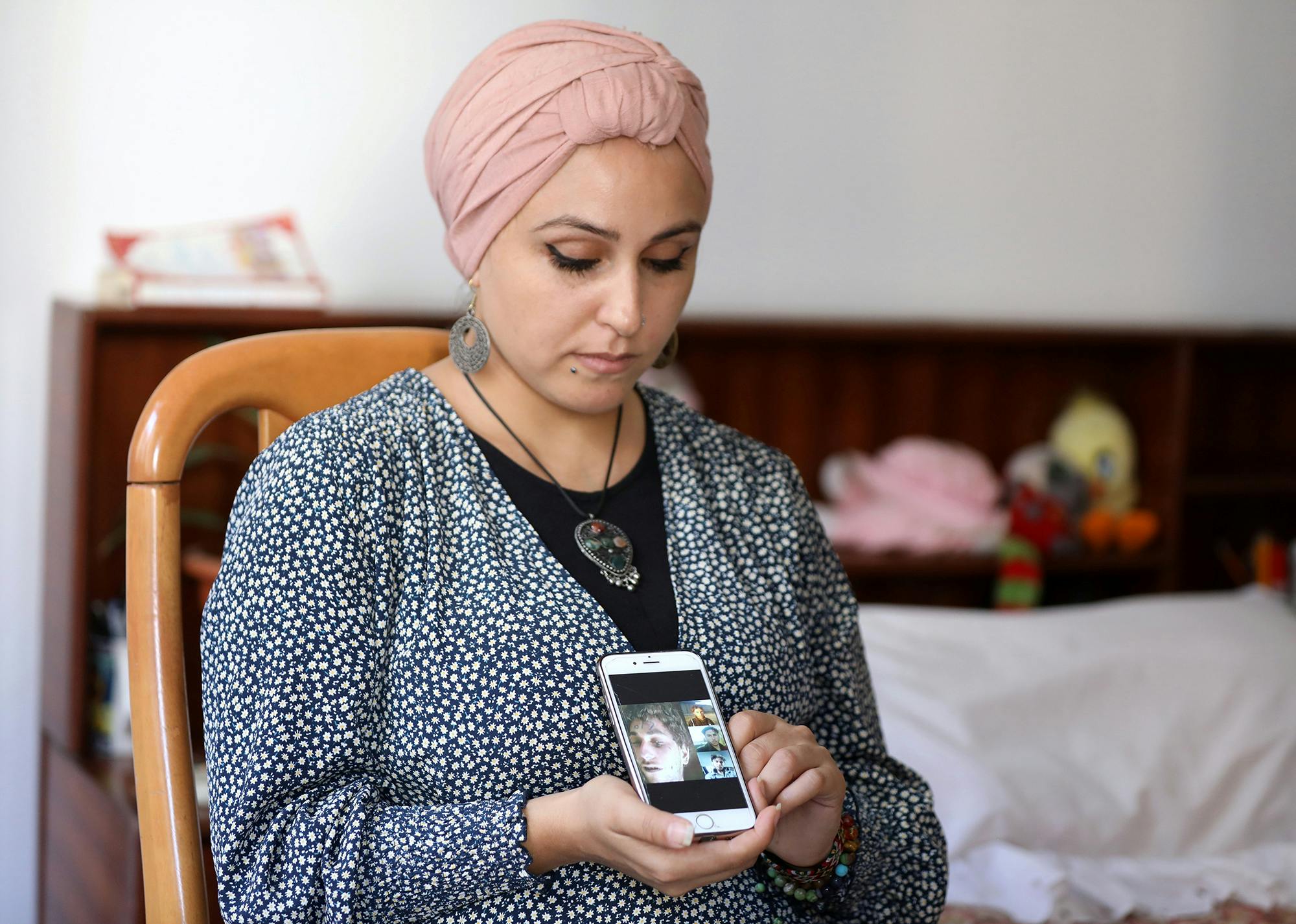 Fida Al Waer, une artiste et enseignante syrienne vivant à Beyrouth, pose en tenant un téléphone portable sur lequel s'affichent des photos de son frère qui, selon elle, a été identifié parmi des milliers d'images, sorties clandestinement de Syrie par un ancien photographe militaire syrien