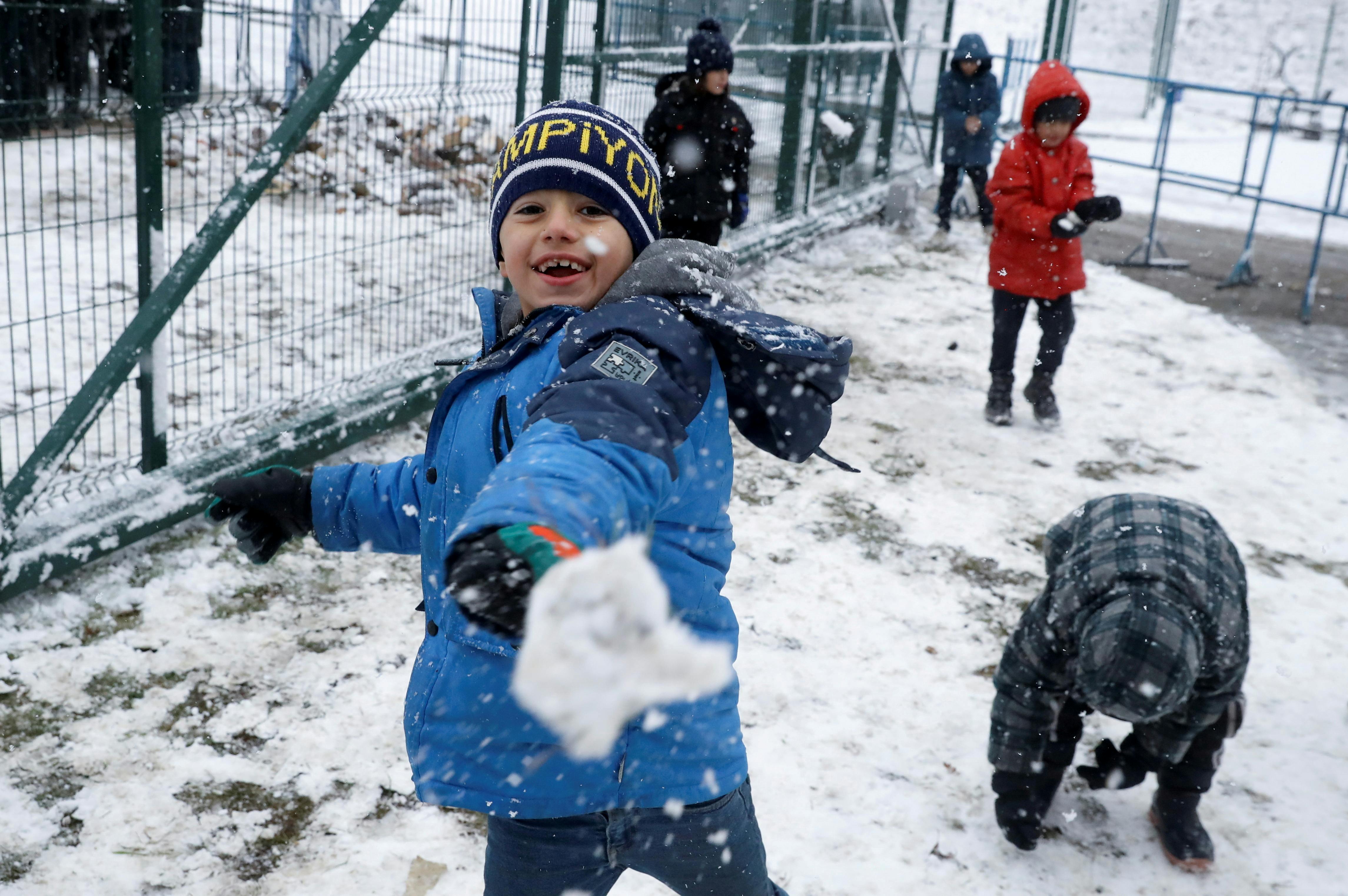 Des enfants migrants jouent dans la neige dans un centre de transport et de logistique près de la frontière biélorusse-polonaise, dans la région de Grodno, en Biélorussie, le 23 novembre 2021. REUTERS/Kacper Pempel 