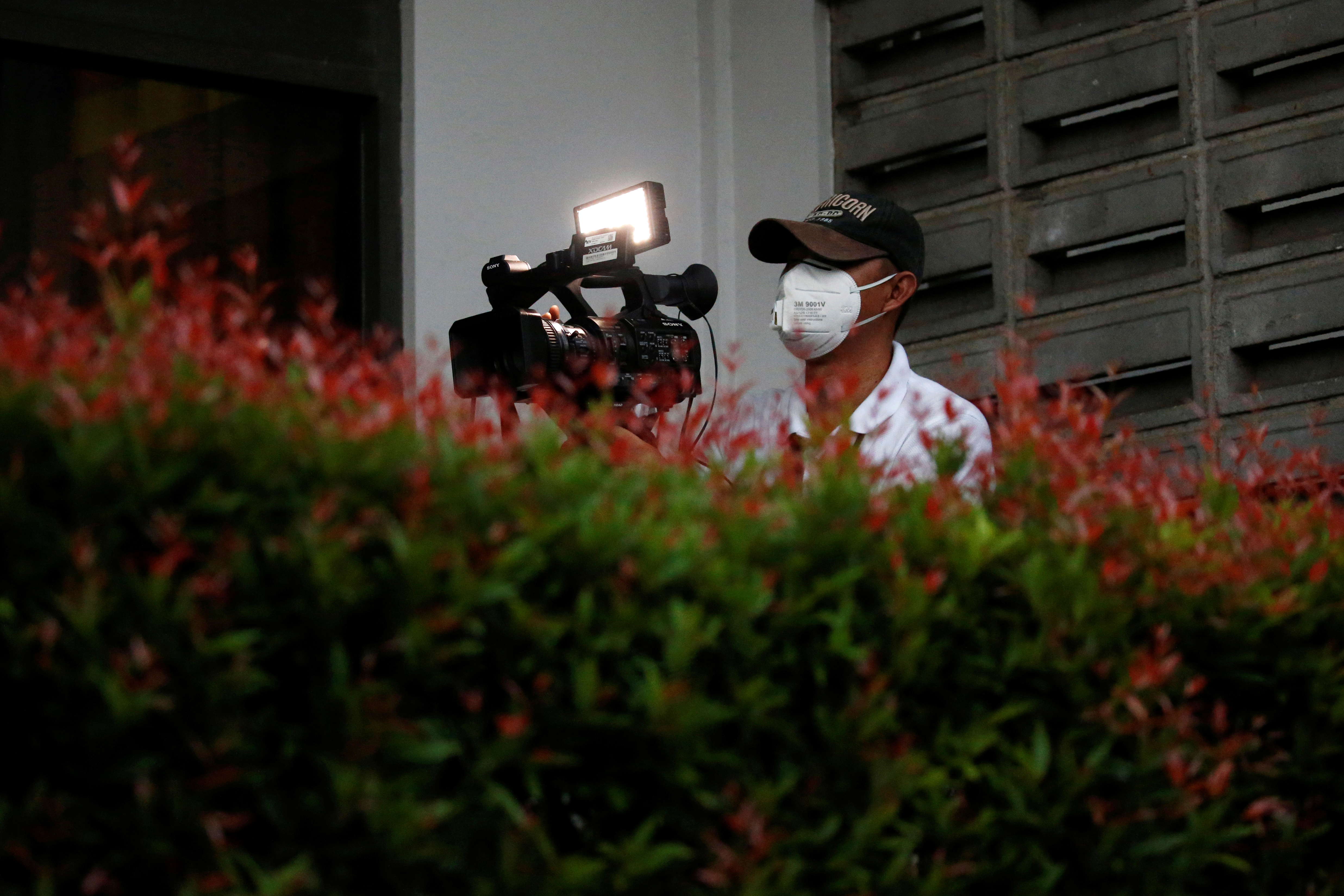 A video journalist wearing a protective mask uses a camera at Halim Perdanakusuma airport, following the outbreak of the coronavirus in China, in Jakarta, Indonesia, February 15, 2020. REUTERS/Willy Kurniawan