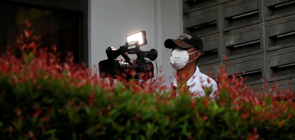 A video journalist wearing a protective mask uses a camera at Halim Perdanakusuma airport, following the outbreak of the coronavirus in China, in Jakarta, Indonesia, February 15, 2020. REUTERS/Willy Kurniawan