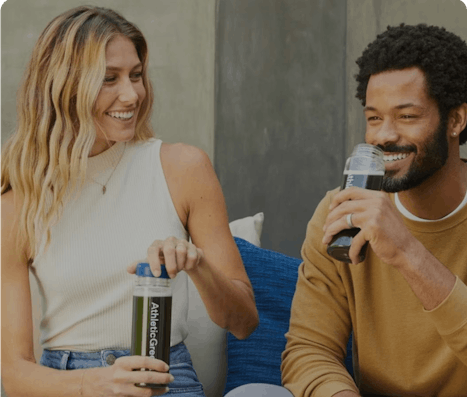 Photo of two people drinking Athletic Green's supplement powder