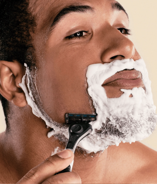 Photo of a man shaving with a razor from Dollar Shave Club