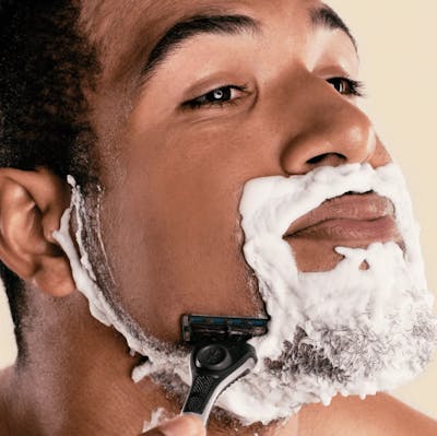 Photo of a man shaving with a razor from Dollar Shave Club