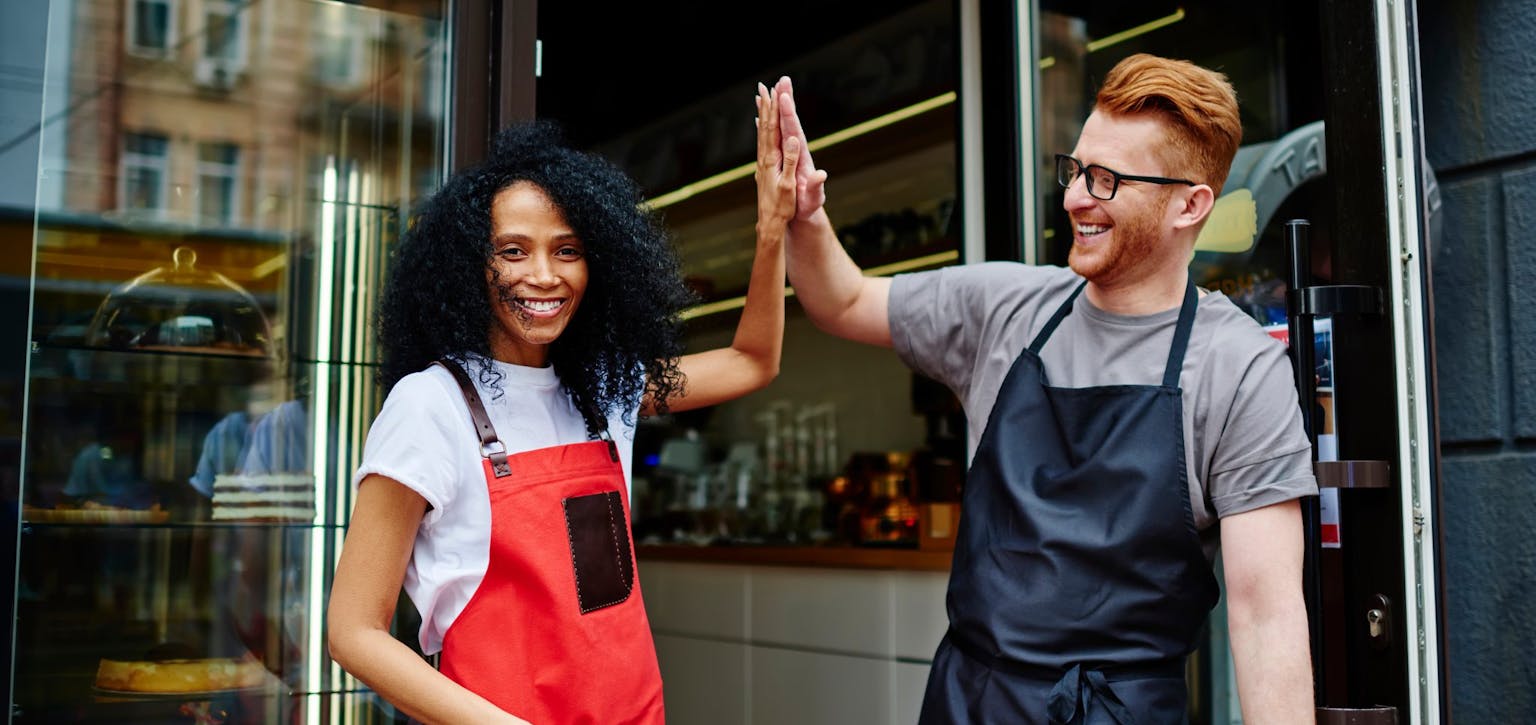 2 people in aprons, giving a high 5