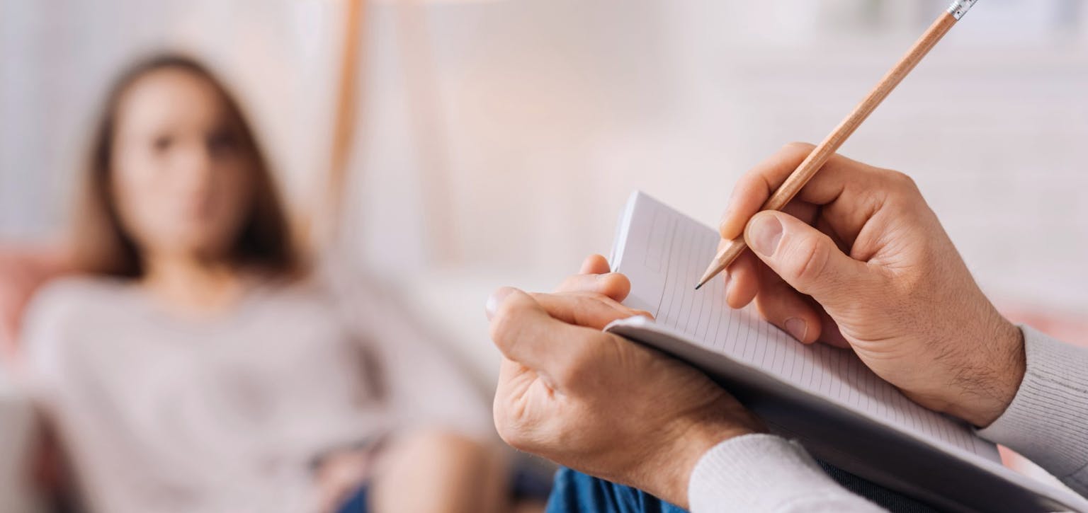 person writing on notepad