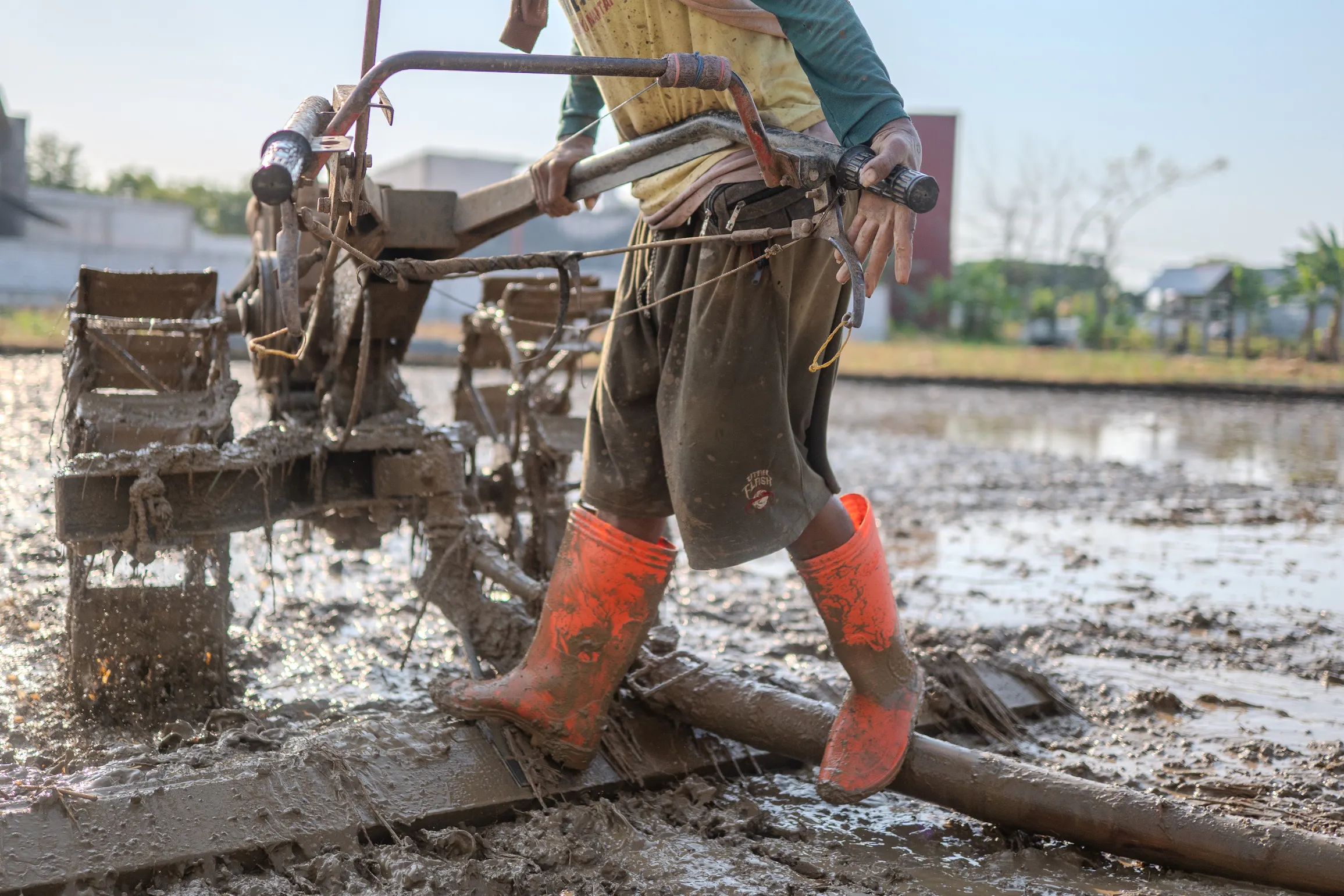 pemakaian ando boots dalam membajak sawah di industri pertanian