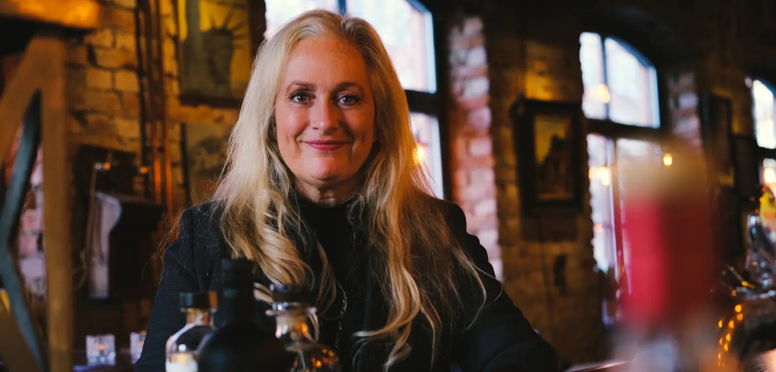 Angela sitting at a table in a bar