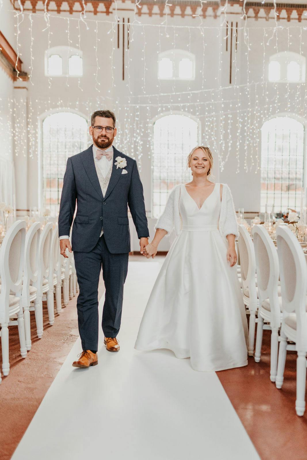 glückliches Brautpaar in festlich geschmücktem Saal (Foto: Nina Stiller))