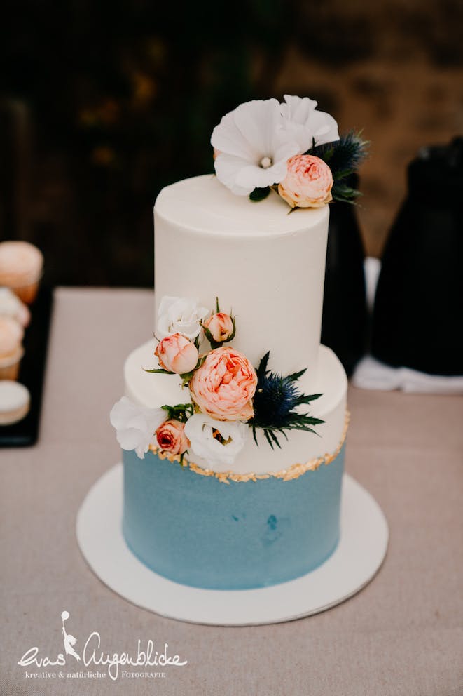 Hochzeitstorte Blau-weiß mit Blüten