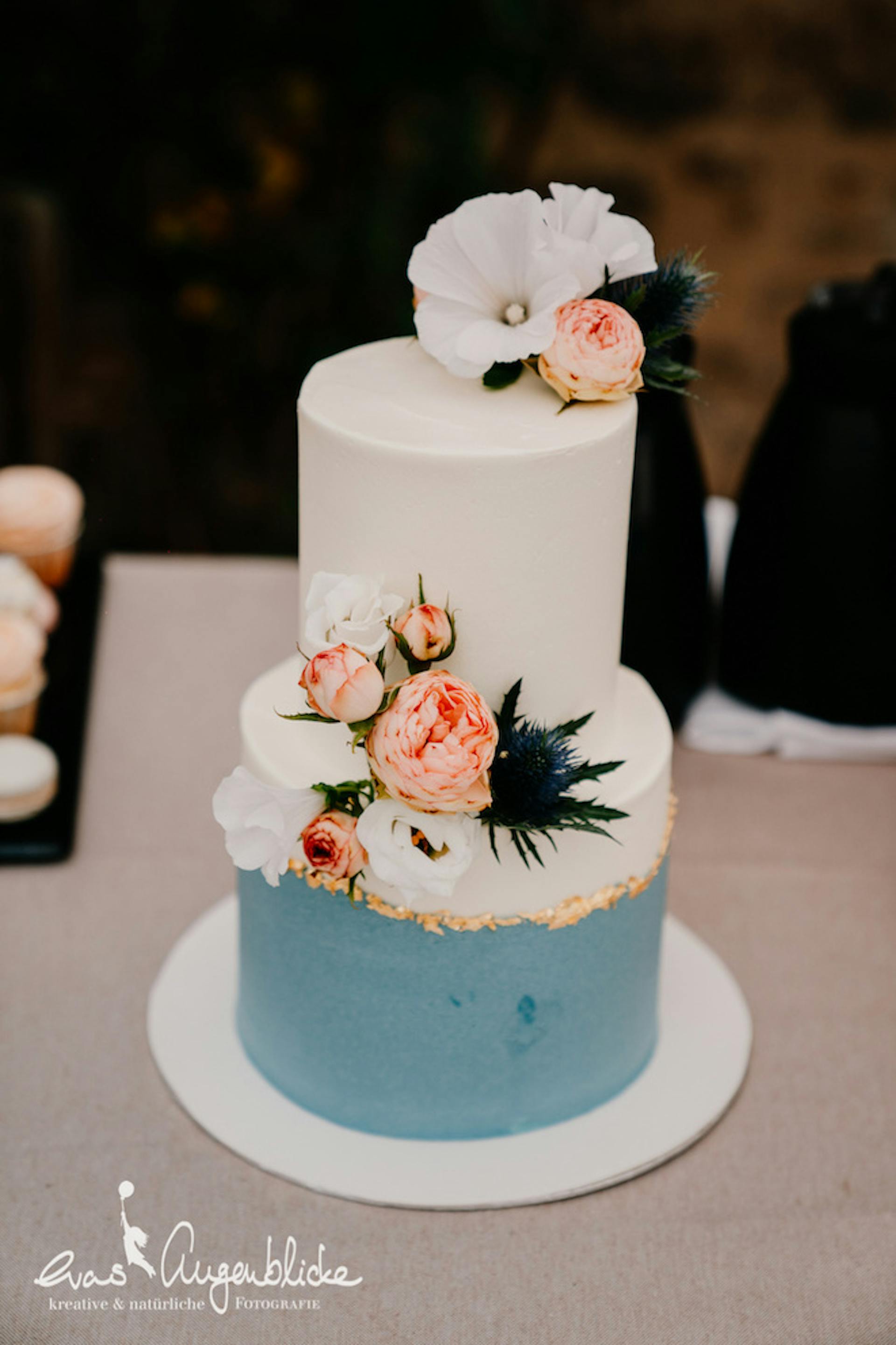 Hochzeitstorte Blau-weiß mit Blüten