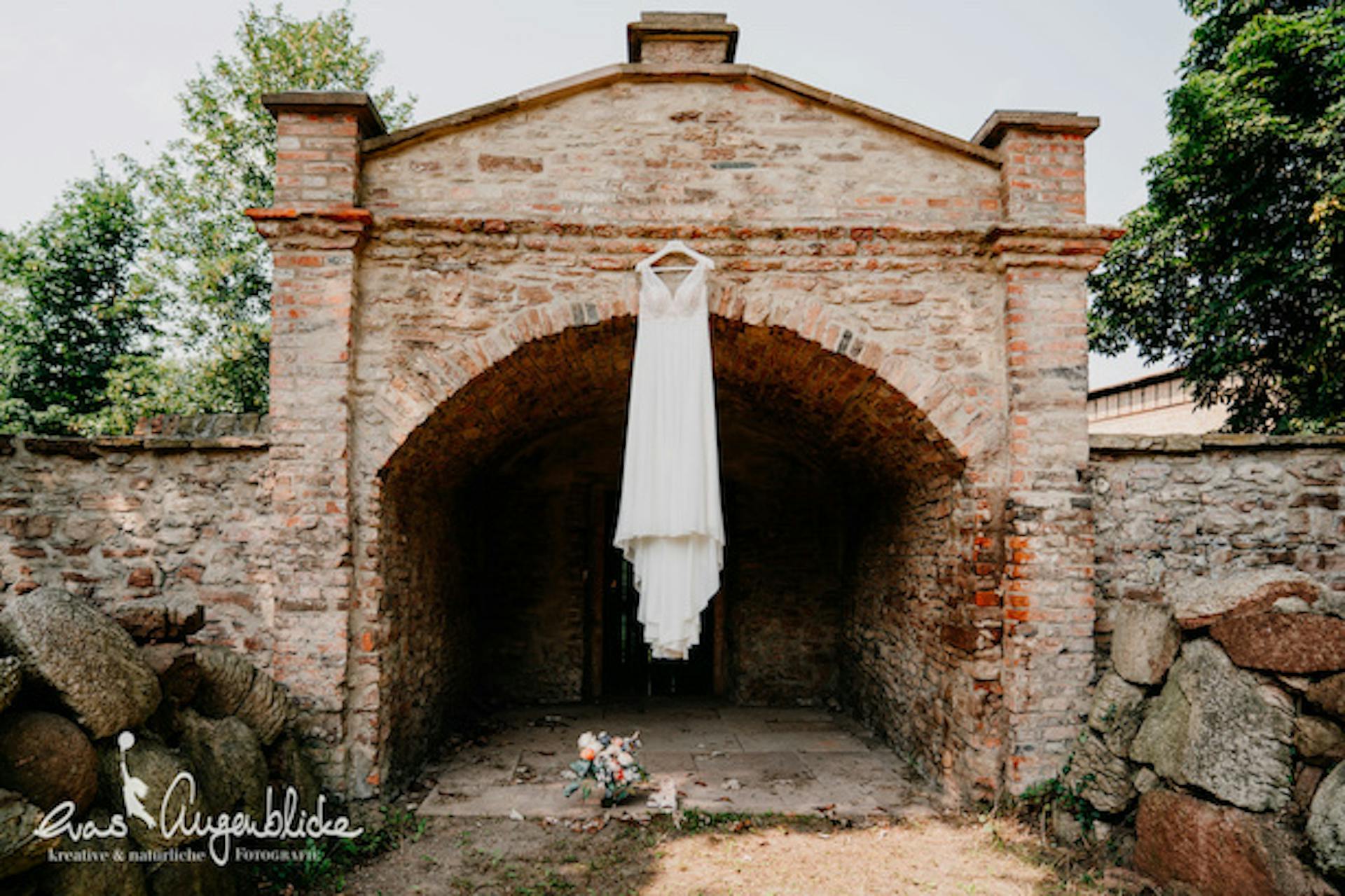 Brautkleid auf einem Bügel im Garten am Gewöbe