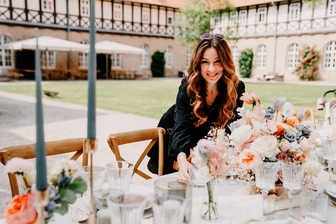 Hochzeitsplaner Anja Habel am dekorierten Hochzeitstisch im Klosterhotel Wöltingerode