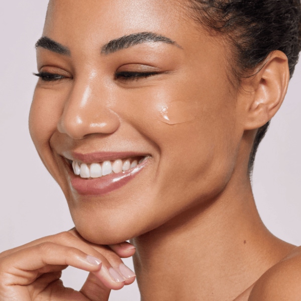 A female patient smiling after receiving gentle facial treatment