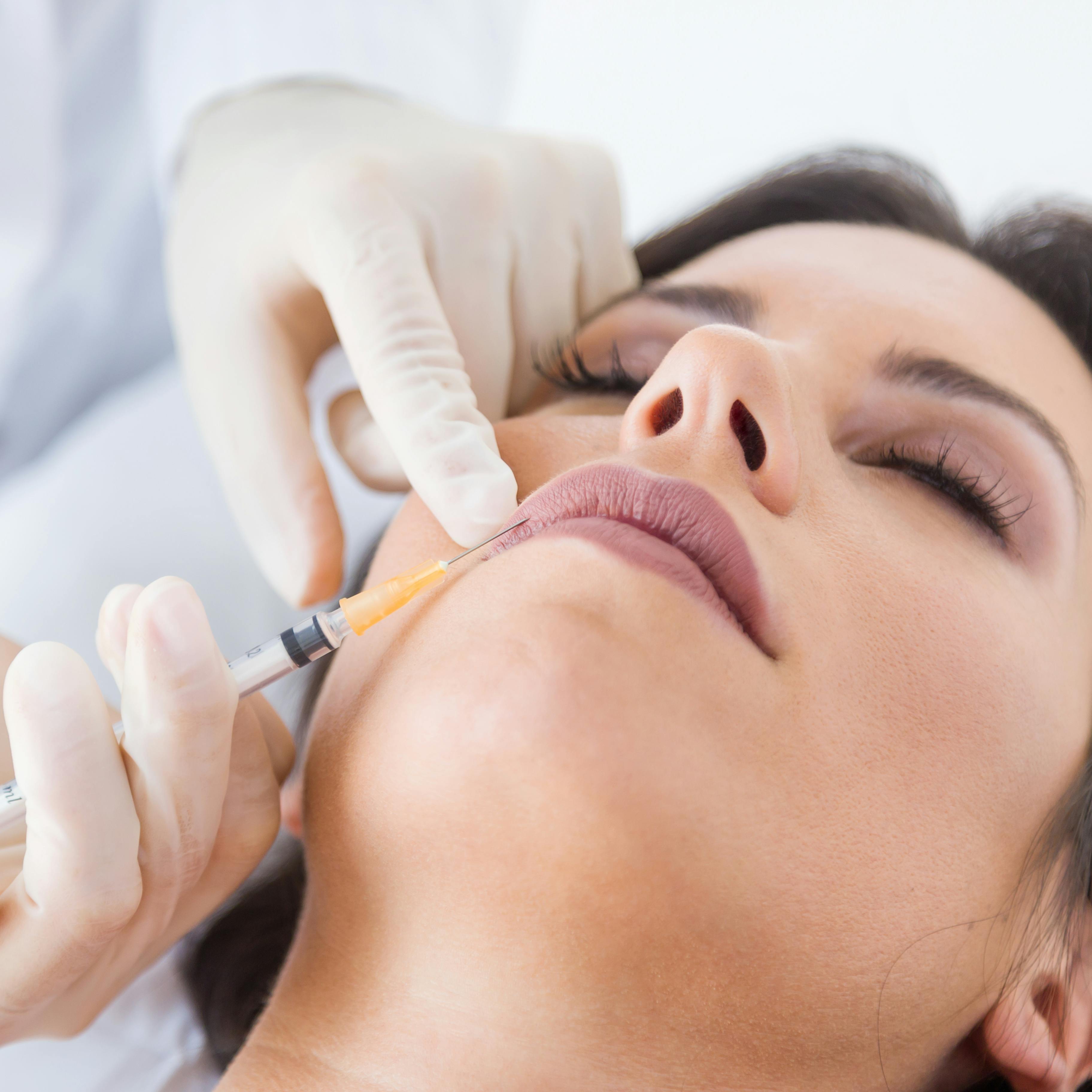 A female patient receiving dermal filler injection treatment