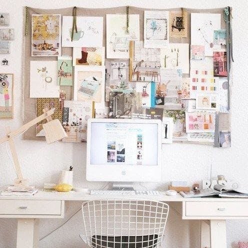 Un escritorio con un vision board en la pared