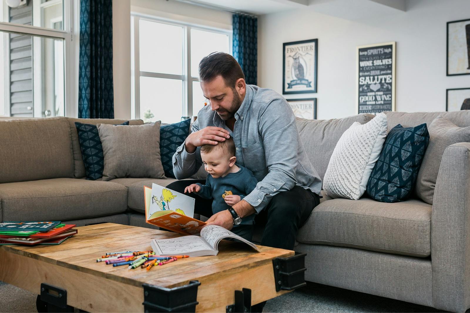 A father reads to his son on a couch