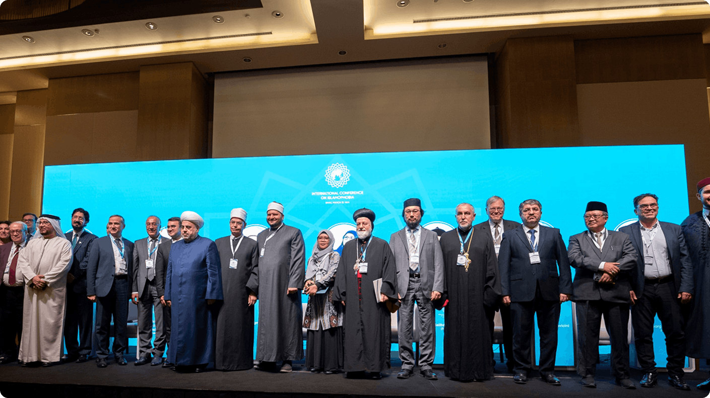 Conference participants standing together on stage with blue backdrop