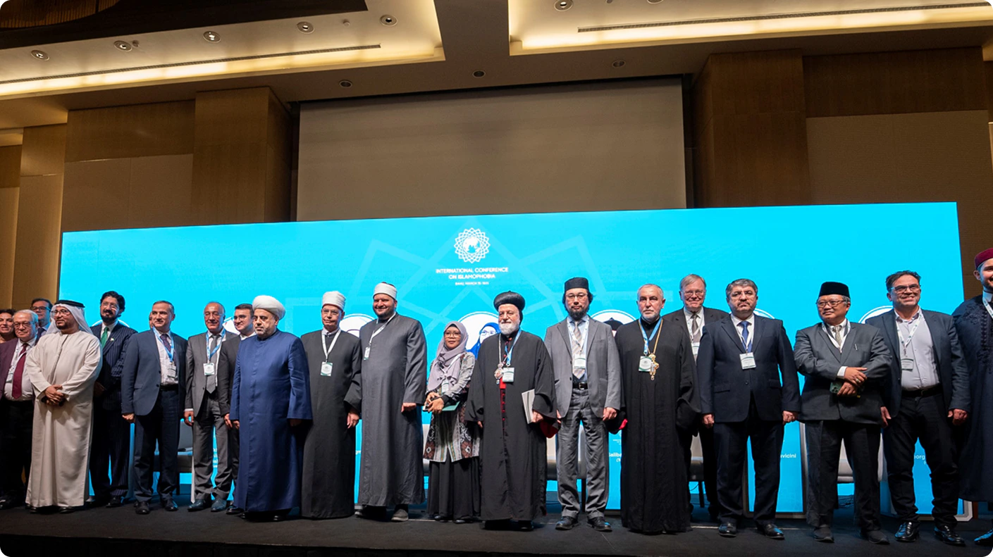 Conference participants standing together on stage with blue backdrop
