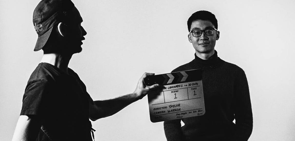 A director holding a clapperboard in front of a model