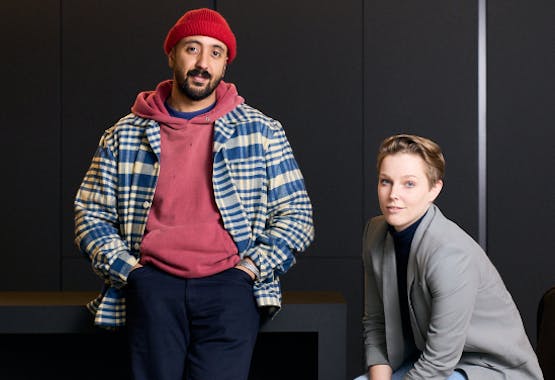Photo of two Antisocial team members posing by a desk.