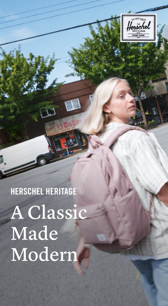 A woman crossing the street wearing a pink backpack with the text A Classic Made Modern