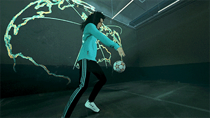 Looping 3D animation of Real Madrid kit floating inside a glowing outline of planet Earth and Spanish footballer Ivana Andrés demonstrating football skills.