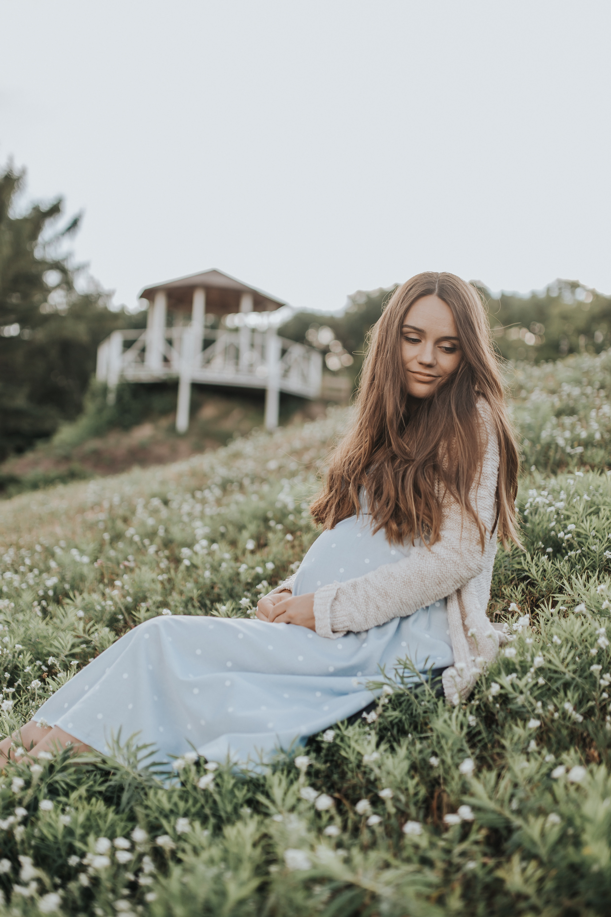 pregnant women sitting on meadow