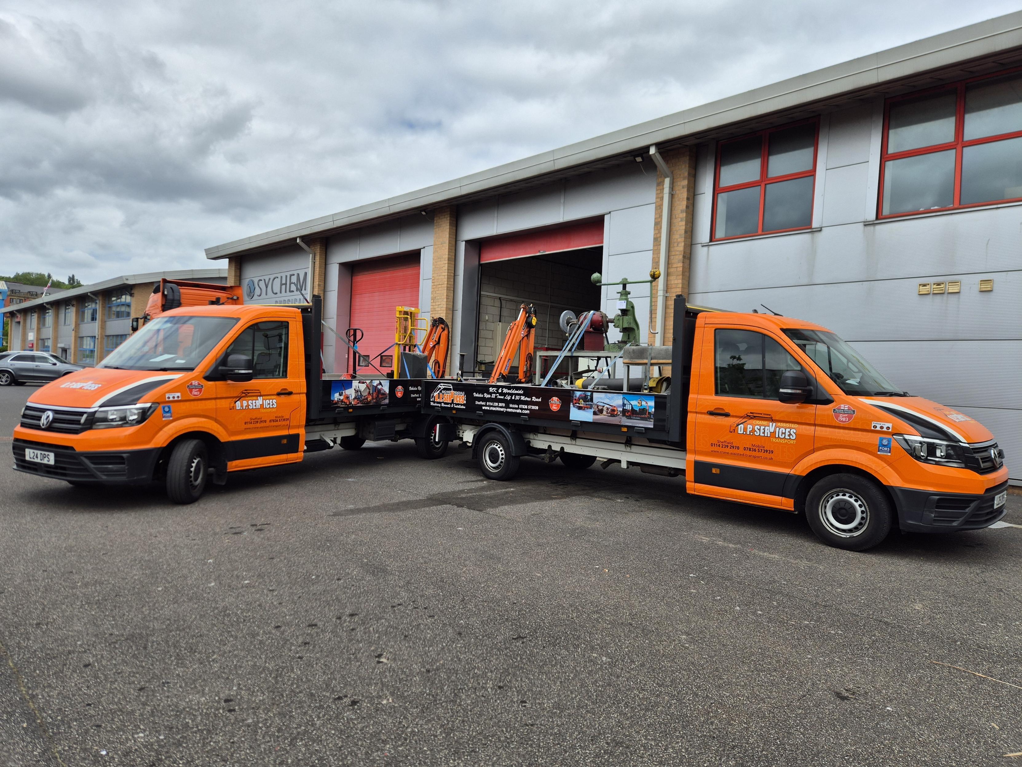 Image of two flat bed transit trucks