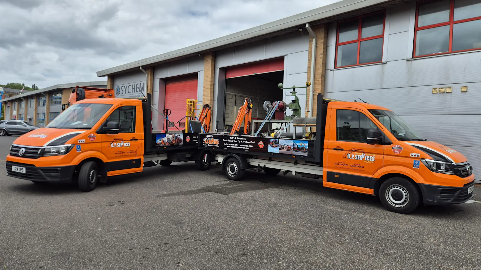 Image of two flat bed transit trucks
