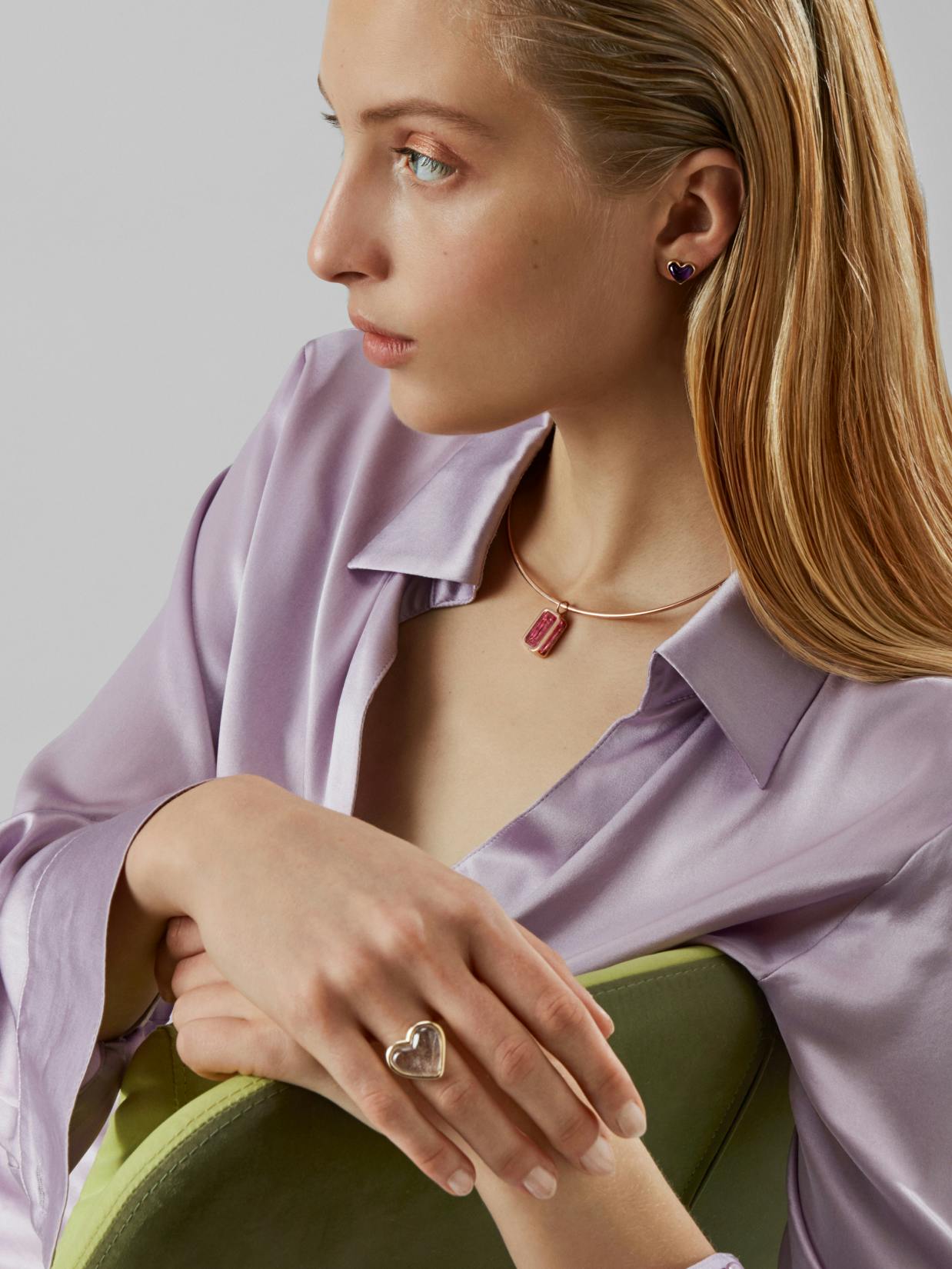 Alina Abegg – Branding "A cosmic shopping experience": Photo showing a woman wearing heart earrings, a pink crystal pendant necklace, and a heart-shaped ring by HY.AM