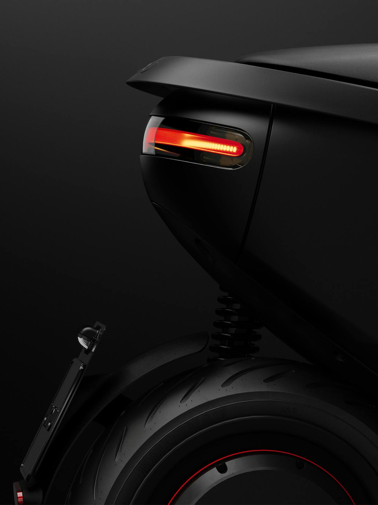 unu – Brand Design, E-Commerce, Experience Design "Discovering your city with unu": Photo showing the rear detail of a black electric scooter with its red brake light illuminated x HY.AM Studios